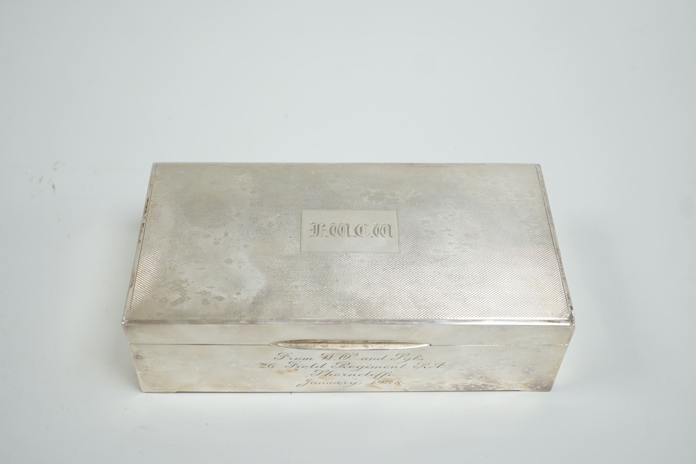 A Elizabeth II engine turned silver mounted rectangular cigarette box, 17.8cm, with engraved inscription, Birmingham, 1952.